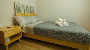 A single bed with a wooden frame, a bedside table with a lamp, and a wall-mounted artwork. - Voon Cottages@Pinjistation Private Pool 10pax (Ipoh)