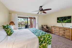 A bedroom with a bed, a ceiling fan, a wooden dresser, and a TV on the wall. - Big Island Waikoloa Colony Villas 2004 2 Bedroom Condo (Waikoloa)