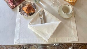 A breakfast table set with various food items, including pastries, fruits, and beverages, on a marble table with a white tablecloth. - PALAZZO RICARDI (Imperia)