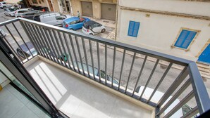 A balcony with a view of parked cars and buildings. - Spacious & Cozy 4-Bedroom in Sliema JELL1-2 (Sliema)