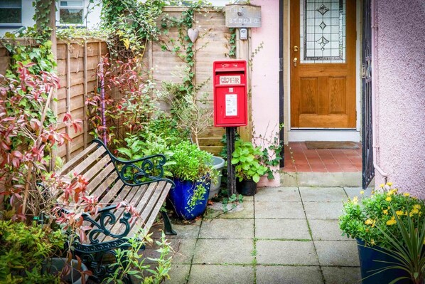 A wooden bench, a red mailbox, and a door with a glass panel.