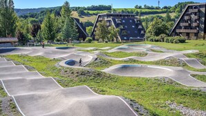 Una pista de skate con varias rampas y una persona montando en bicicleta.