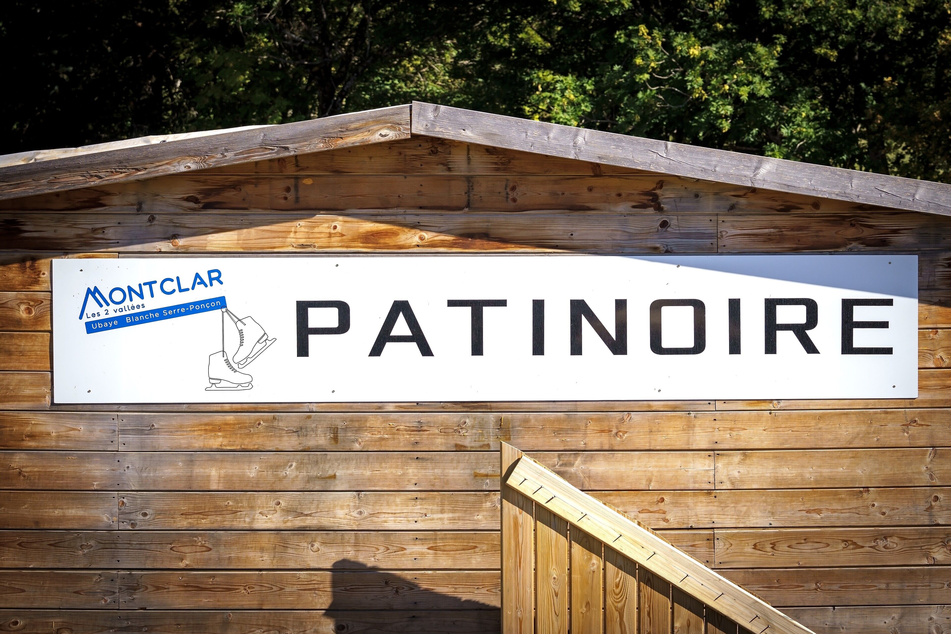 A wooden building with a sign that reads 'PATINOIRE' and 'Montclar Les 2 vallées Ubaye Bissaye Serre-Poncon.'