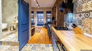 A modern kitchen with a wooden countertop, a stove, and a backsplash with patterned tiles. - Ganbaru Tours - Private Triplex&Duplex (Istanbul)