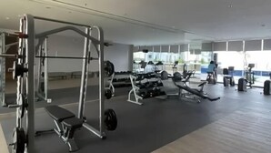 A gym with various exercise equipment, including weight machines and free weights. - 2 BR ANDERSON 25floor above pakuwon mall the biggest shopping center (Wiyung)