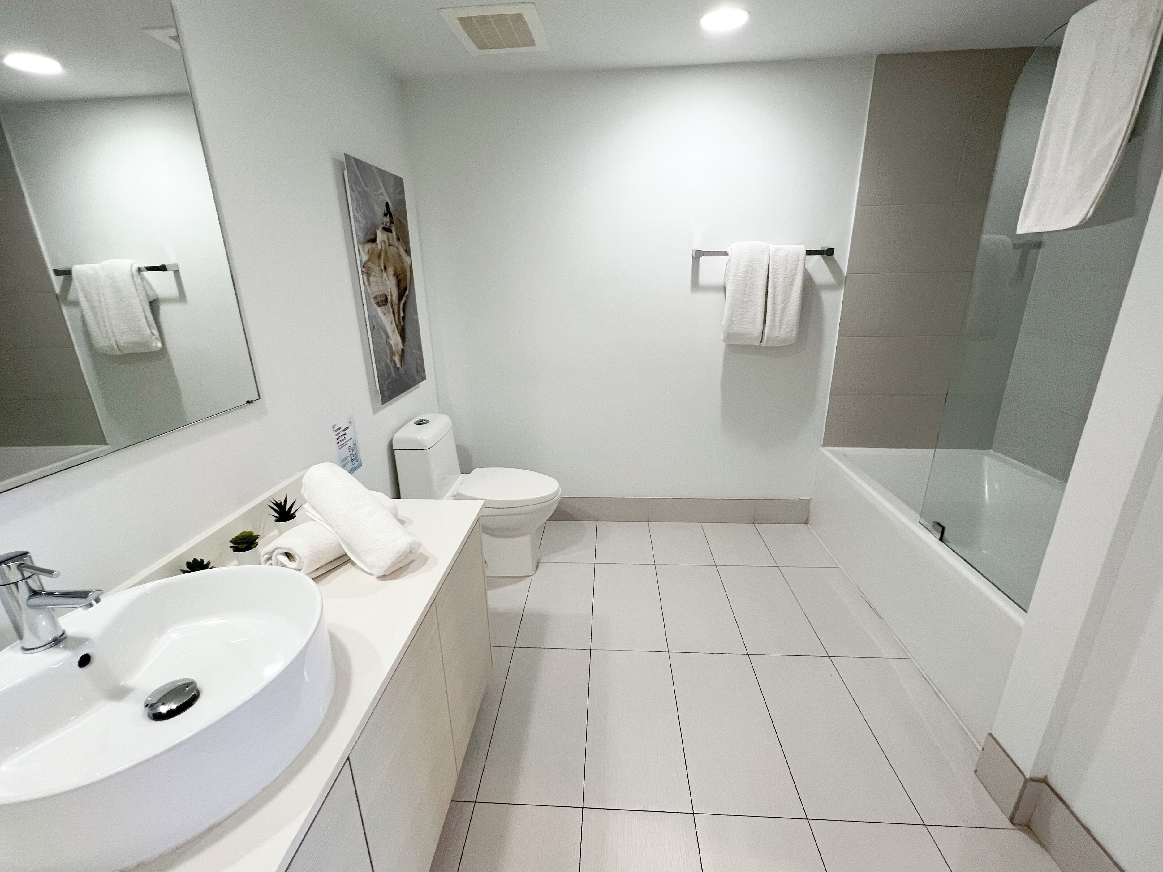 A modern bathroom with a large sink, toilet, and bathtub.