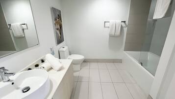 A modern bathroom with a large sink, toilet, and bathtub.