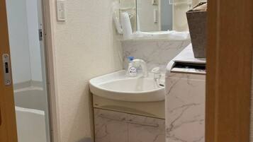 A bathroom with a white sink, mirror, and marble-patterned walls.