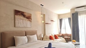 A hotel room with a large bed, a desk, and a chair. There is a painting on the wall and a window with curtains. - Soho Residence-Tony Apartment (Ho Chi Minh City)
