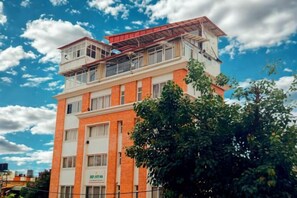 A multi-story building with a flat roof and a sign indicating it is a hospital. - Deepjyoti Inn (Kathmandu)