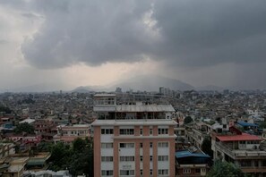 A cityscape with buildings and a cloudy sky. - Deepjyoti Inn (Kathmandu)