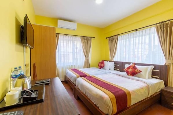 A hotel room with a bed, bedside table, and a TV.