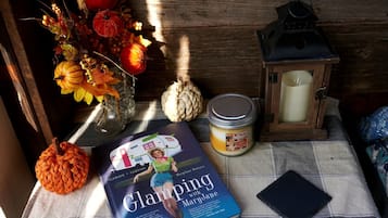 Une table avec un livre, une bougie, une lanterne et des citrouilles décoratives.