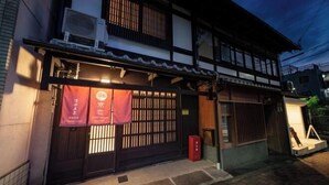 A traditional Japanese building with a dark wooden gate, a red banner, and a small red mailbox. - Kyokoi Kiyomizu Gojo (Kyoto)