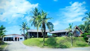 A building with a sign reading "WELCOME" at the entrance, surrounded by palm trees and a clear sky. - Marang Guesthouse Resort (Rusila)