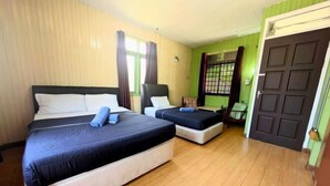 A hotel room with two beds, a wooden floor, a green wall, and a door. - Marang Guesthouse Resort (Rusila)