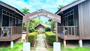 A wooden archway with the text "Welcome Marang Guest House" leading to a building with a porch and a small garden. - Marang Guesthouse Resort (Rusila)