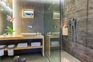 A modern bathroom with a wooden vanity, a glass shower enclosure, and a wall-mounted towel rack. - Arkadia Hotel (Arkadii)