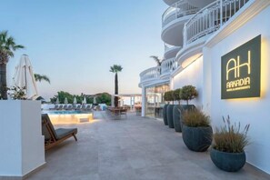 A hotel exterior with a pool, lounge chairs, and a sign reading 'AH ARKADIA'. - Arkadia Hotel (Arkadii)