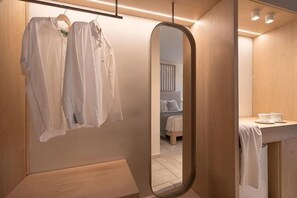 A modern bathroom with a wooden vanity, a hanging robe, and a mirror. - Arkadia Hotel (Arkadii)