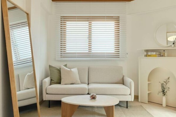 A modern living room with a sofa, a coffee table, and a mirror.