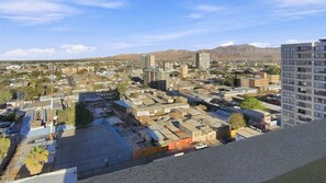 Paisagem urbana com mistura de edifícios residenciais e comerciais, incluindo arranha-céus e casas menores.