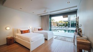 Habitación de hotel moderna con dos camas, un ventanal grande y vista a una piscina.