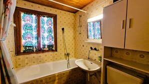 A bathroom with a bathtub, sink, and shower.