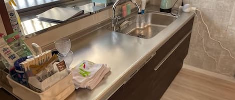 A kitchen with a stainless steel sink, a microwave, and a coffee maker.