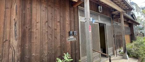 Un edificio tradicional de madera con puerta de madera y un pequeño porche.
