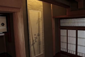 A traditional Japanese room with sliding doors, a tatami mat floor, and a shoji screen.
