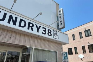 Un bâtiment avec une enseigne indiquant « LUNDRY38 » et un panneau de signalisation indiquant une zone de stationnement.