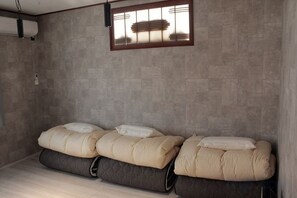 A room with a bed, a window with blinds, and a wall-mounted air conditioning unit. - KYOTO TANGO MIYAZU inn (Miyazu)