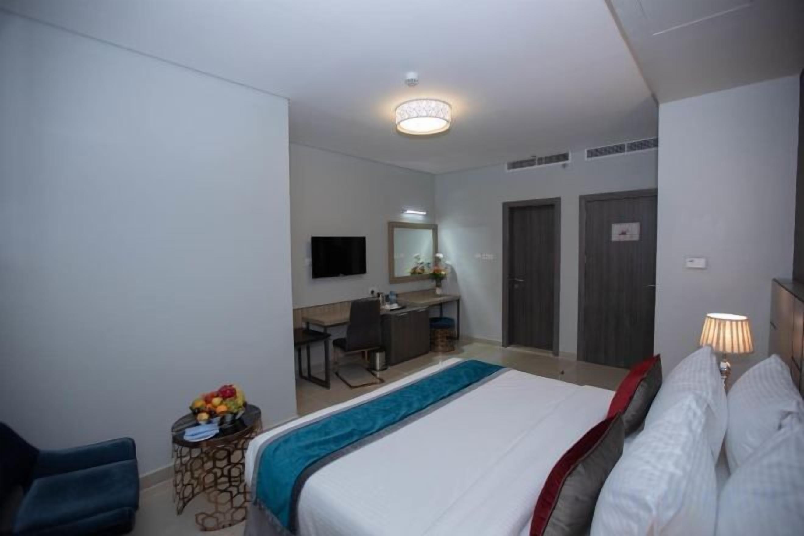 Ein Hotelzimmer mit Bett, Schreibtisch, Stuhl und Fernseher.