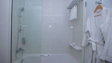 Une salle de bain moderne avec une douche à parois de verre, une baignoire blanche et un porte-peignoir en bois.