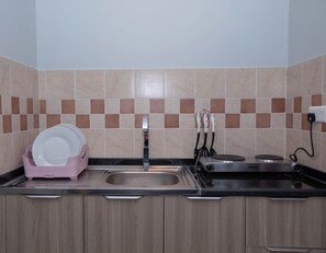 A kitchen with a sink, countertop, and tiled backsplash.