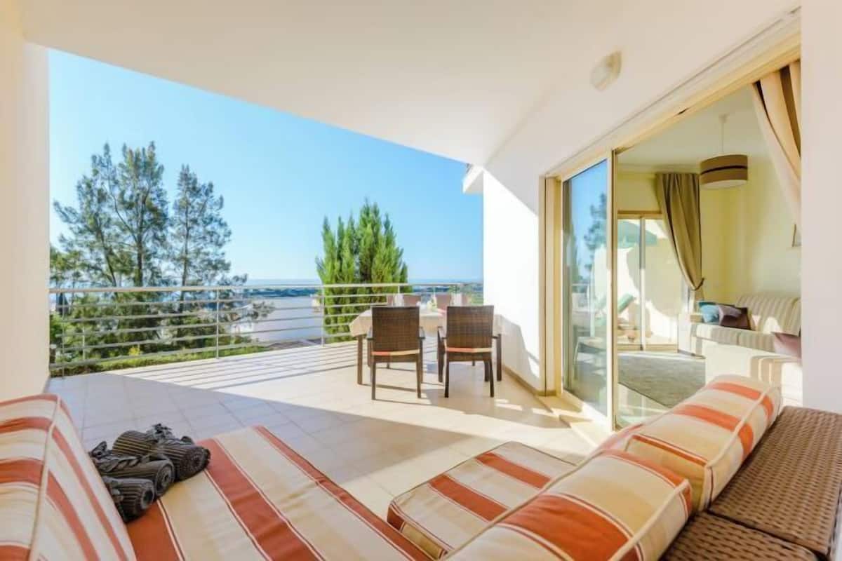 A balcony with a sofa, chairs, and a table.