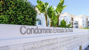A white wall with a sign reading "Condominio Encosta Da Orada" and a row of numbered mailboxes below. - BnB Homes Ocean View Apartment with Huge Sunny Terrace, 2 Swimming Pools & Tennis Court (Albufeira)