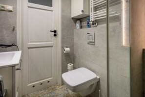 Ein Badezimmer mit Toilette, Waschbecken und Duschbereich.