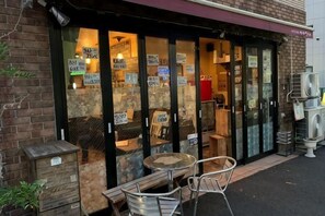 Un ristorante con posti a sedere all'aperto, inclusi tavolo e sedie, e una facciata in mattoni.