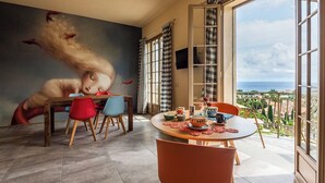 A dining area with a table set for four, a large window with curtains, and a view of the sea. - Apartment No. 4 ( CIN: IT008031B48RJTC5CL Citra 008031-LT-1323 ) (Imperia)