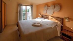 Una habitación de hotel con una cama grande, un cabecero de madera, una ventana con cortinas y una pared decorada con placas.