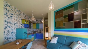 Un espacio habitable compacto con kitchenette, comedor y sofá.