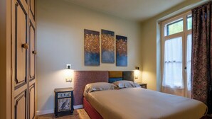A bedroom with a bed, two bedside tables, a headboard, and three wall-mounted paintings. - Apartment no. 3 ( CIN: IT008031B423CF7JSW Citra 008031-LT-1489 ) (Imperia)