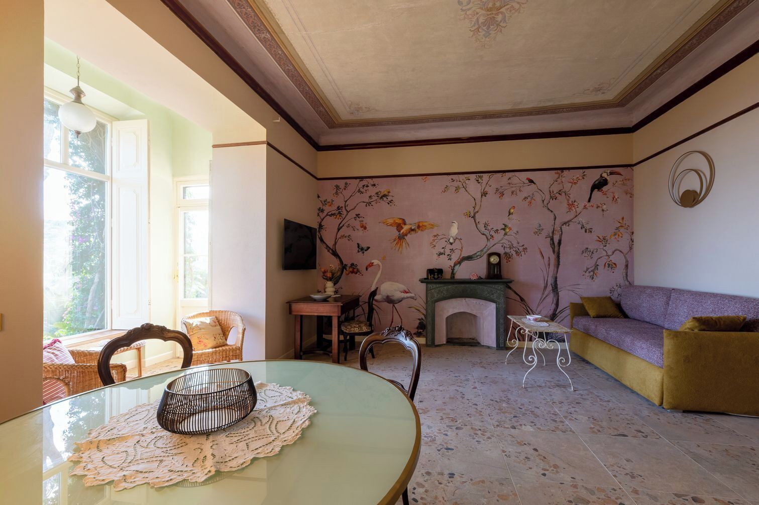 A room with a fireplace, a sofa, a dining table, and a chair.