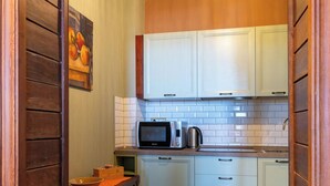 A kitchen with white cabinets, a microwave, and a kettle on the counter. - APARTMENT No. 7 ( CIN: IT008031B4KQZ5NP5U Citra 008031-LT-1493 ) (Imperia)