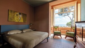 A bedroom with a large bed, a painting on the wall, a window with a view, and a wooden cabinet. - APARTMENT No. 7 ( CIN: IT008031B4KQZ5NP5U Citra 008031-LT-1493 ) (Imperia)