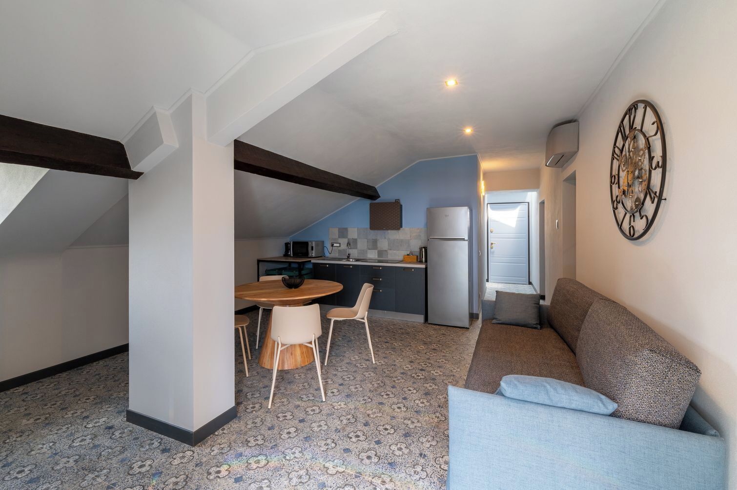 A compact living space with a dining area, kitchenette, and a sofa.