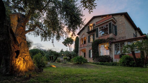 A stone house with a large tree in the foreground, a well-maintained lawn, and a clear sky. - APARTMENT No. 9 ( CIN: IT008031B4324MG4G6 Citra 008031-LT-1495 ) (Imperia)