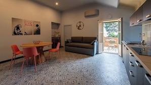 Un espacio habitable compacto con comedor, sofá y kitchenette.